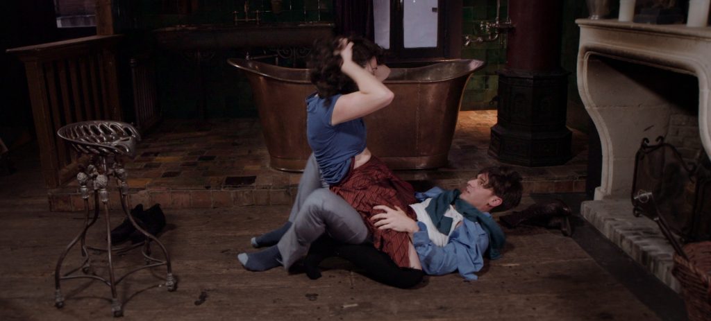 Sadie Lune straddles Parker Marx on the floor in Adorn, an erotic game film directed by Jennifer Lyon Bell for Blue Artichoke Films