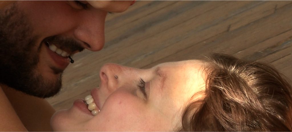 Wim Van Damme and Floor Wyns's smile at each other in Skin.Like.Sun. (Des Jours), an erotic documentary movie directed by Jennifer Lyon Bell and Murielle Scherre available at Blue Artichoke Films